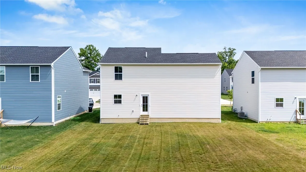 Back of property featuring entry steps and a yard