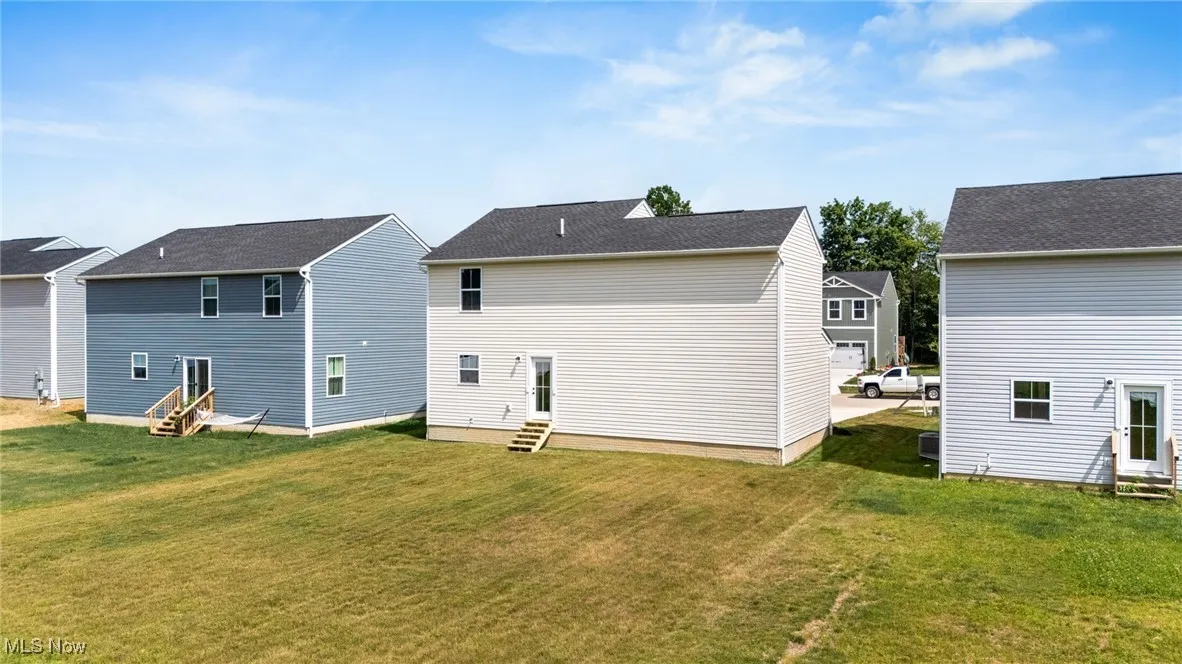Back of property with entry steps and a lawn