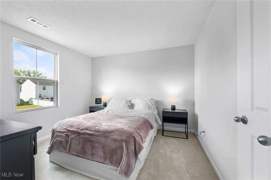 Bedroom featuring baseboards and light carpet