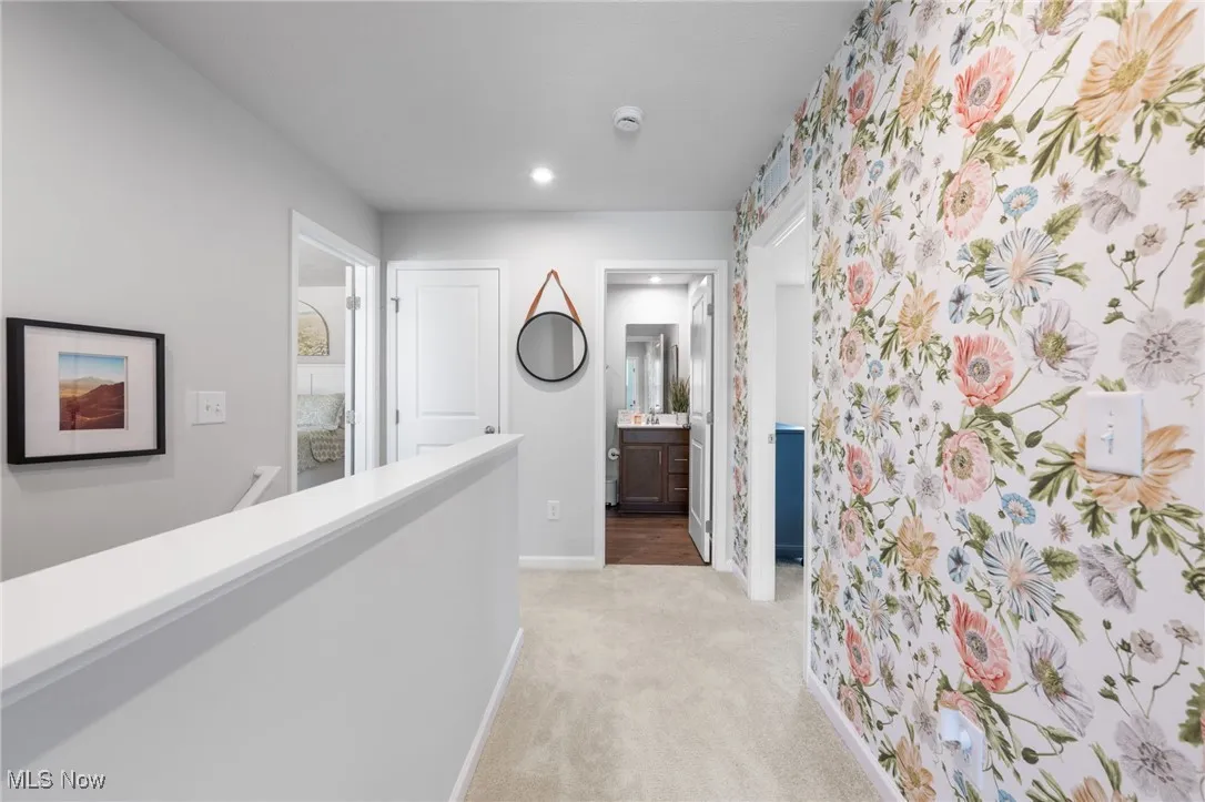 Hall featuring light carpet, an upstairs landing, and recessed lighting