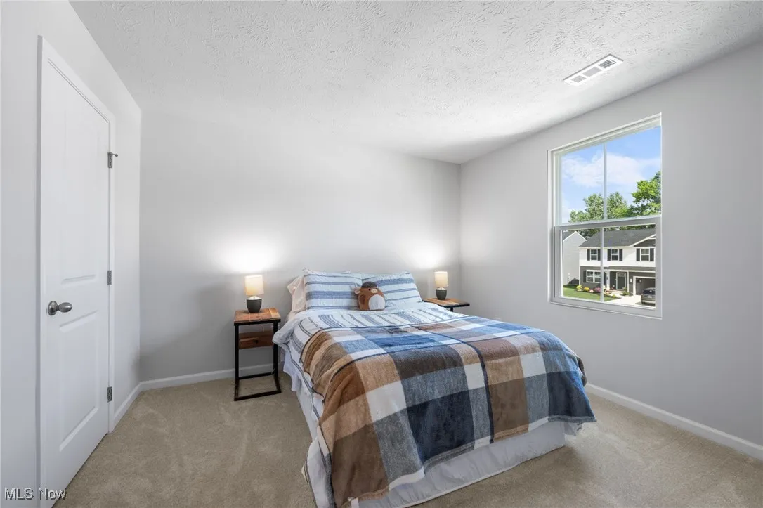 Carpeted bedroom with a textured ceiling