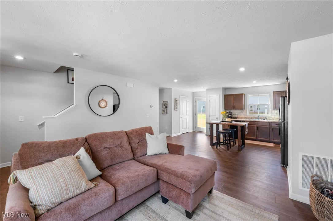Living room with dark wood finished floors and recessed lighting