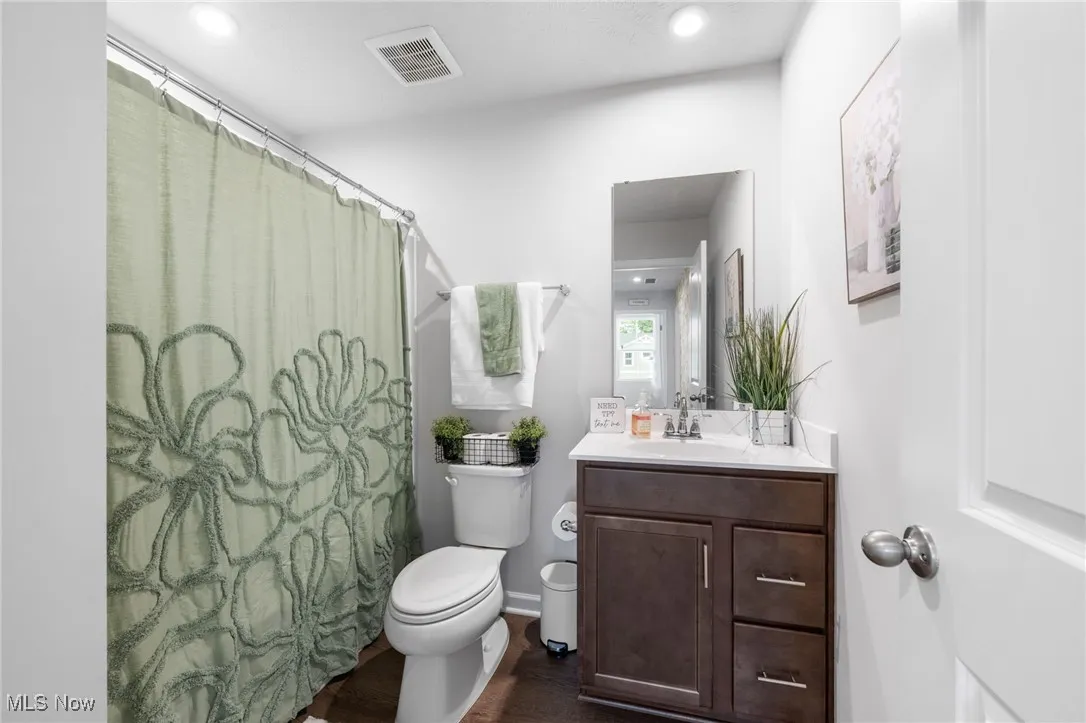 Full bathroom featuring vanity, wood finished floors, recessed lighting, and a shower with shower curtain