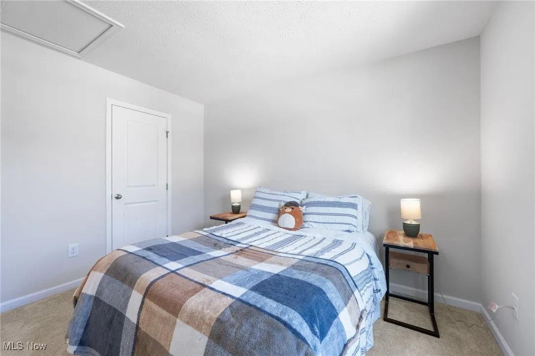 Bedroom with light carpet and attic access