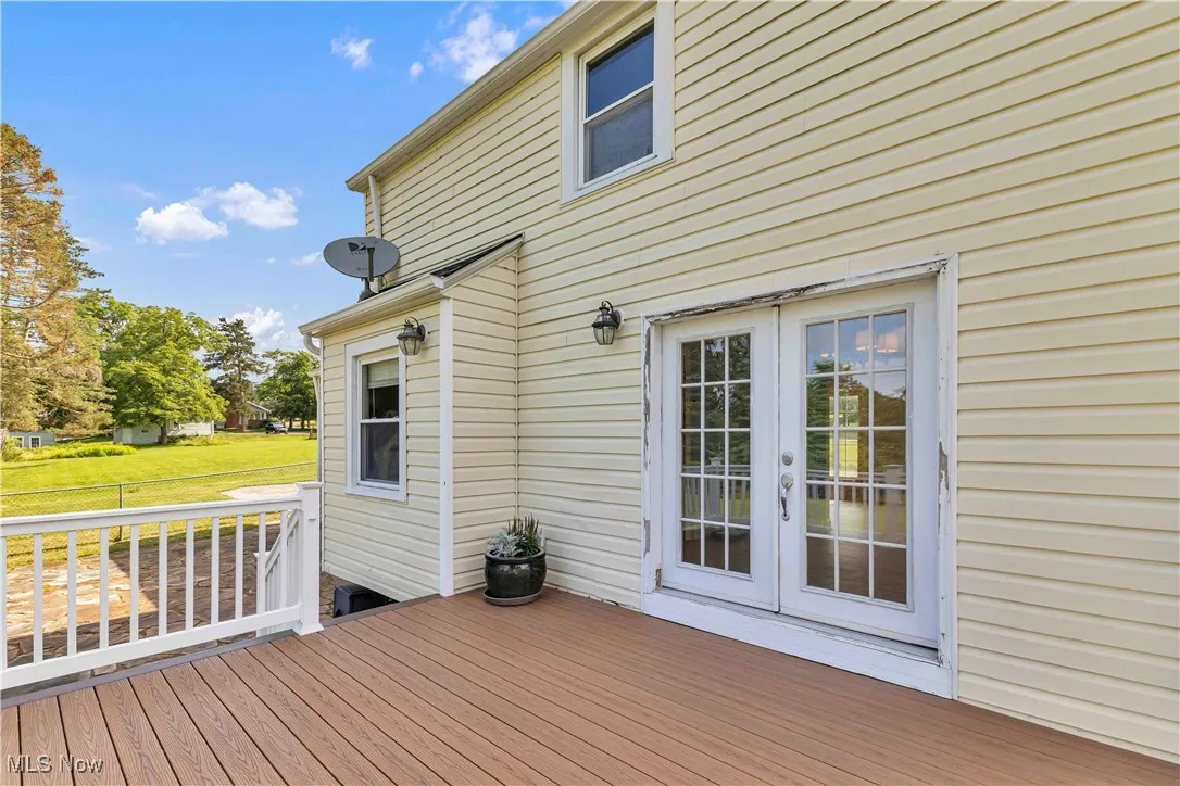 Wooden terrace with french doors and a yard
