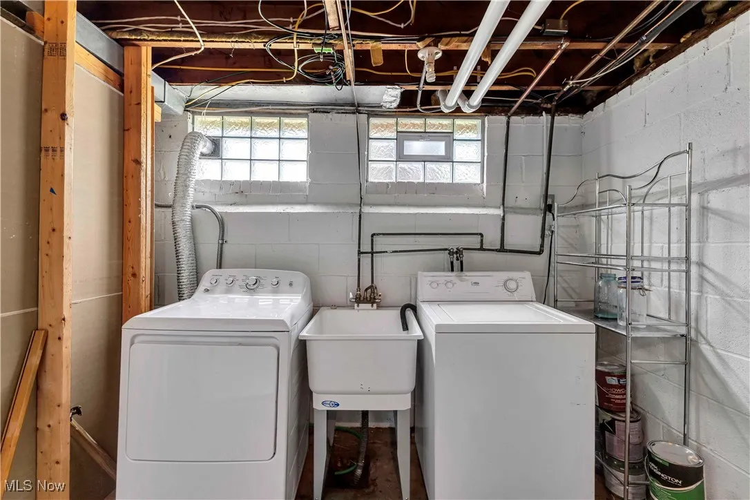 Laundry room with concrete block wall and washer and clothes dryer