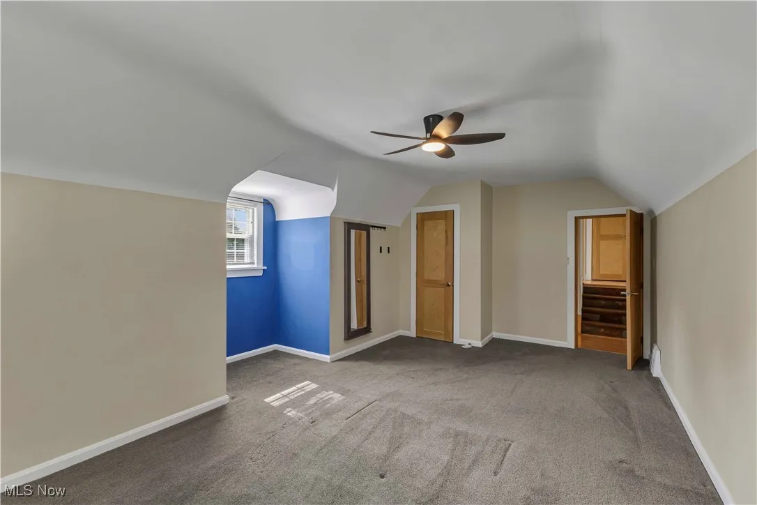 Bonus room with lofted ceiling, a ceiling fan, and carpet floors