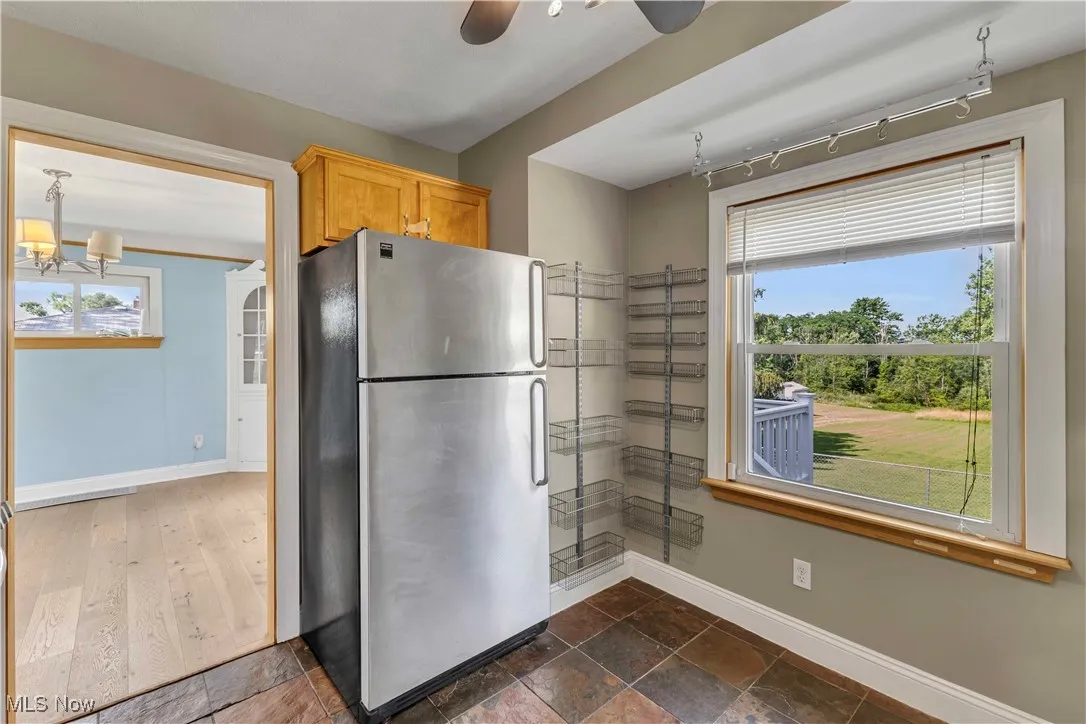 Kitchen with freestanding refrigerator, a chandelier, plenty of natural light, and track lighting