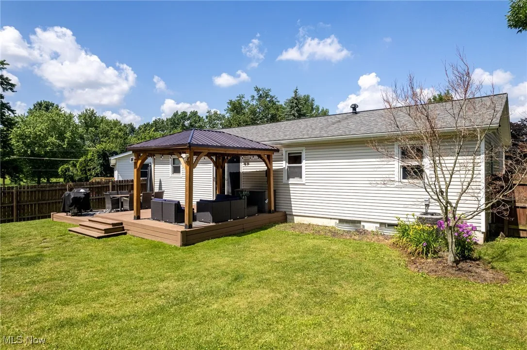 Rear view of house with a gazebo, a wooden deck, and outdoor lounge area