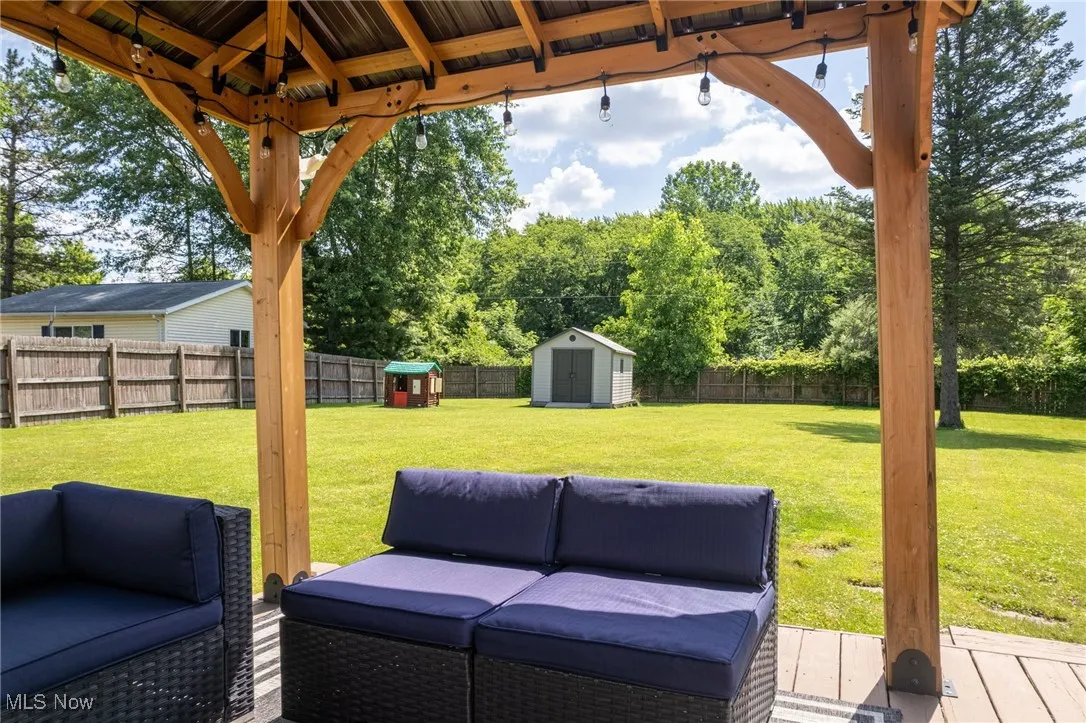 Fenced backyard with a storage unit and an outdoor living space