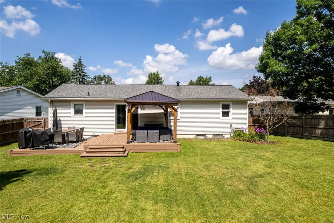 Rear view of house featuring a gazebo, a fenced backyard, outdoor lounge area, and a wooden deck