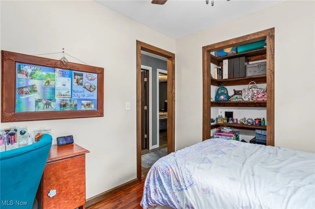 Bedroom with dark wood finished floors and a ceiling fan