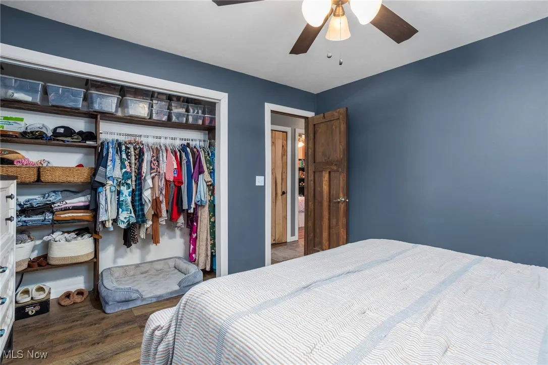 Bedroom featuring wood finished floors, a closet, and a ceiling fan