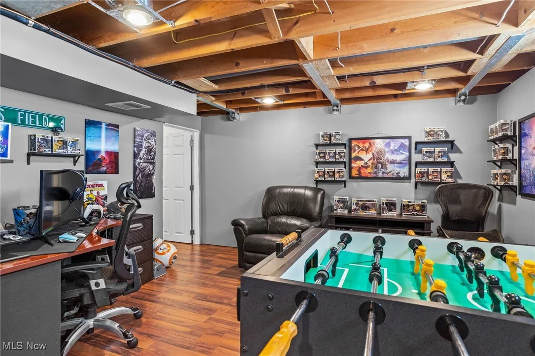 Game room with wood finished floors and a desk