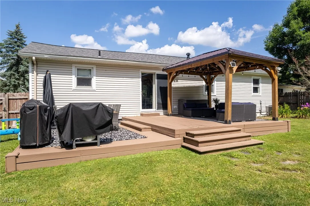 Back of house featuring outdoor lounge area, a wooden deck, and a gazebo