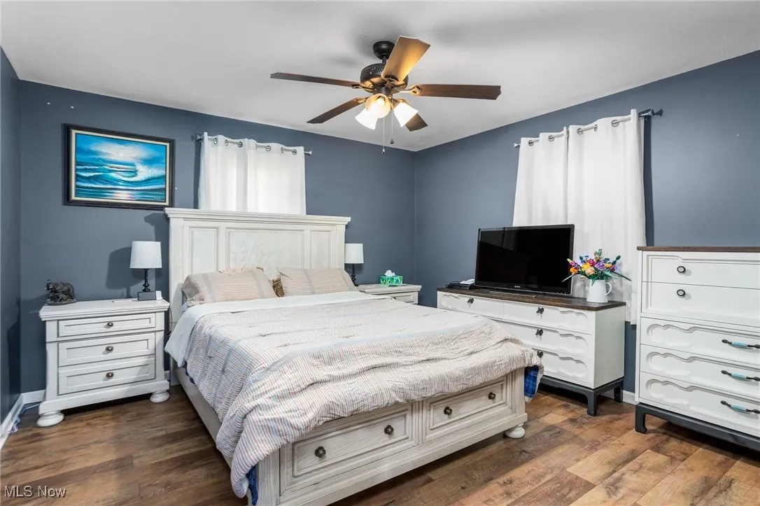 Bedroom with dark wood-type flooring and ceiling fan