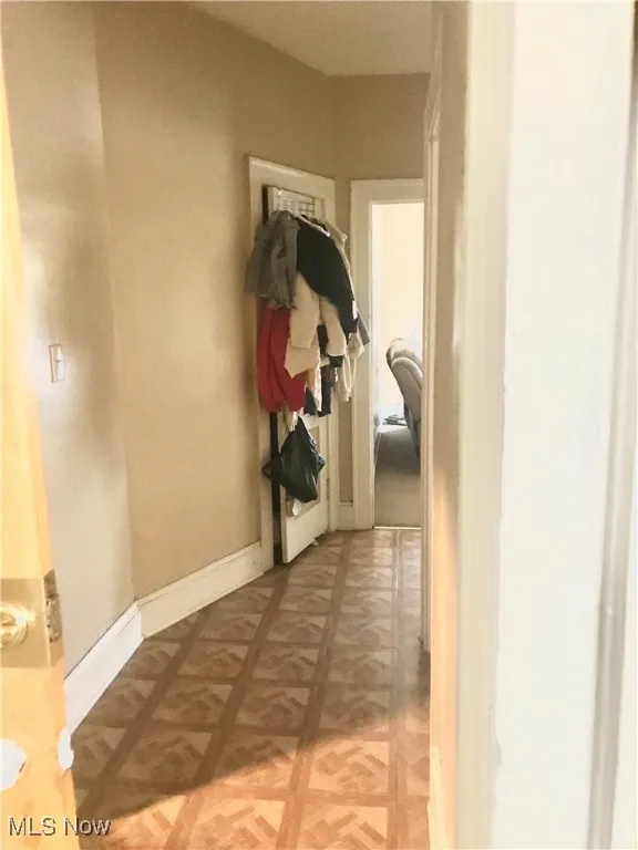 Hallway featuring baseboards and light flooring