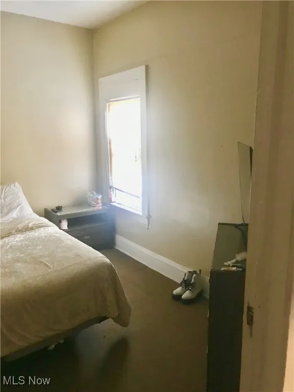 Bedroom featuring baseboards and carpet