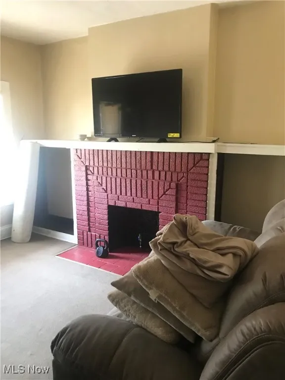 Living room with carpet flooring and a fireplace