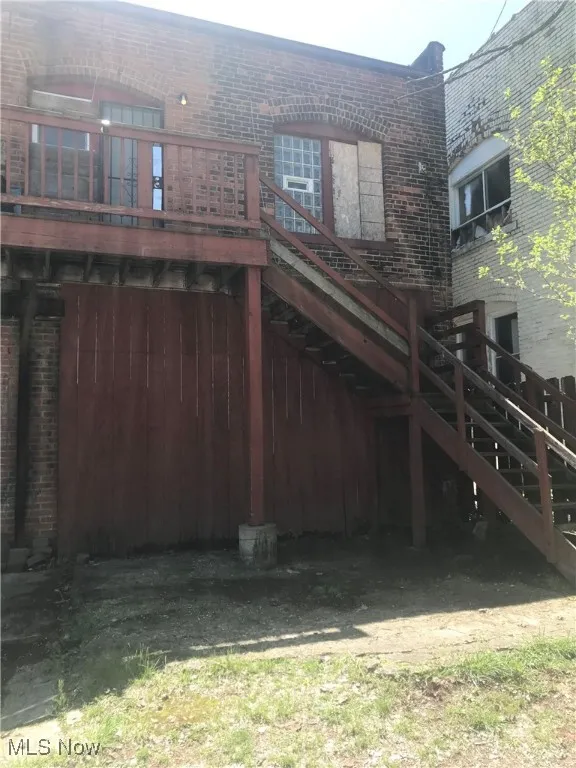 Rear view of house with brick siding and stairway