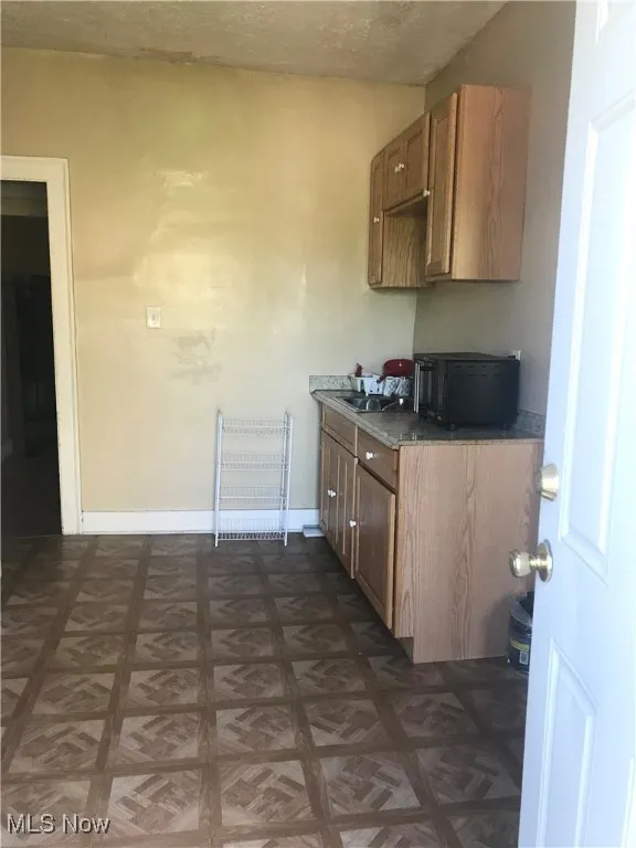 Kitchen with black microwave and baseboards