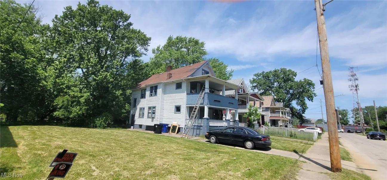 View of side of home with a yard and a balcony