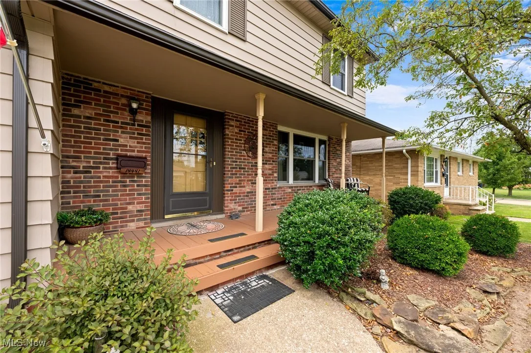 Entrance to property with a porch and brick siding