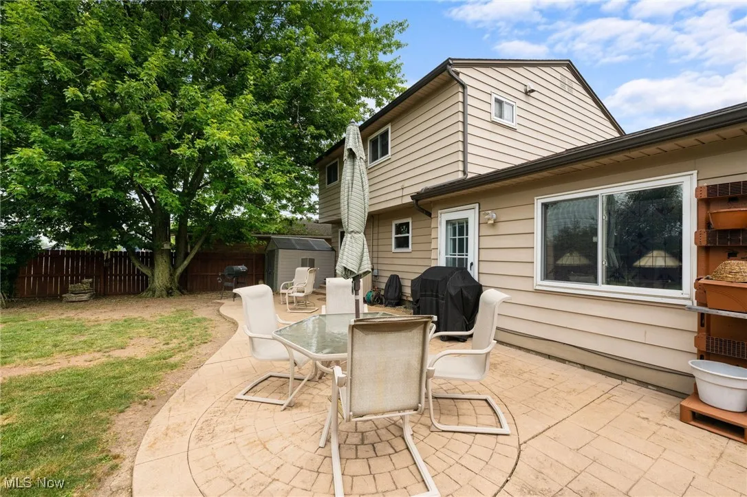 Fenced backyard with a storage unit, grilling area, a patio area, and outdoor dining area