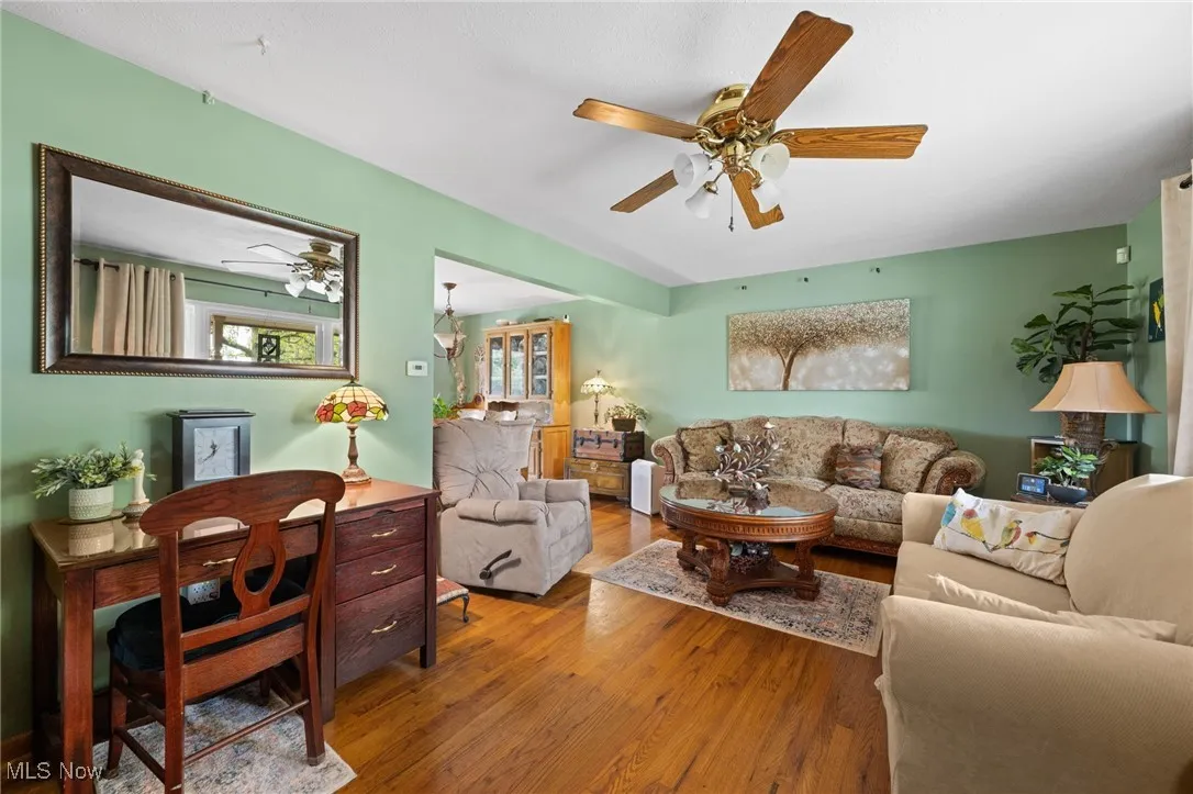 Living area with ceiling fan and wood finished floors