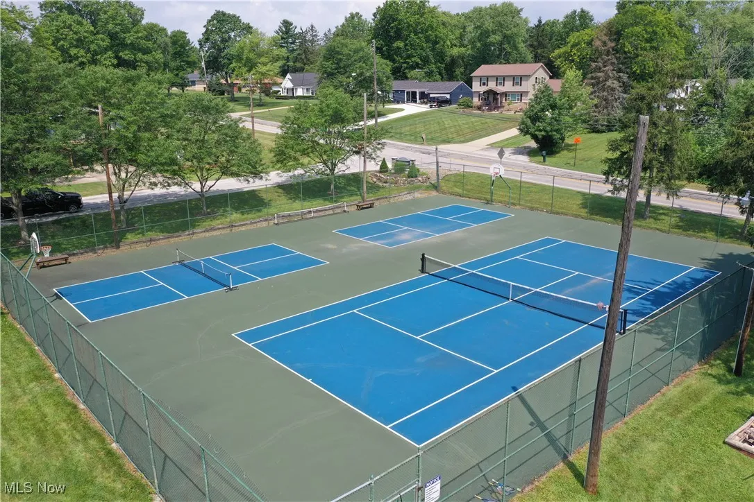 View of tennis court with view of scattered trees