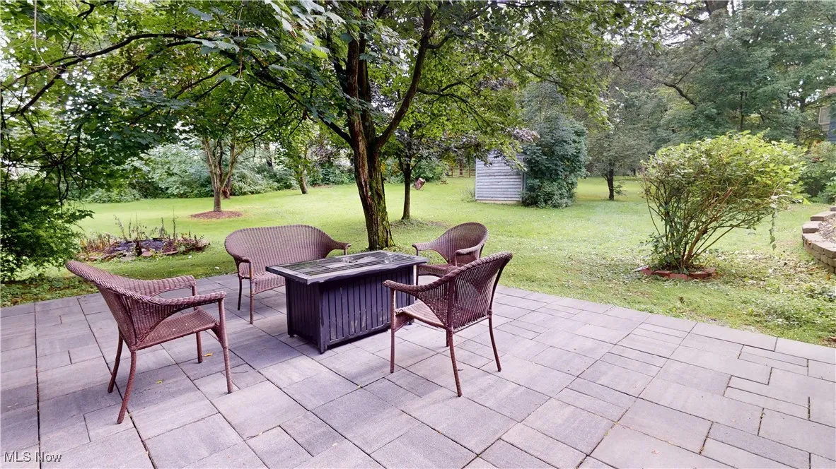 View of patio featuring a fire pit and view of scattered trees