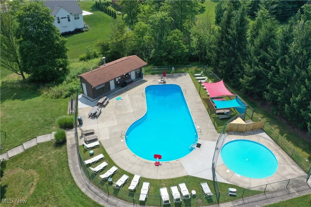 Community pool with a patio area, an outdoor structure, and an exterior structure