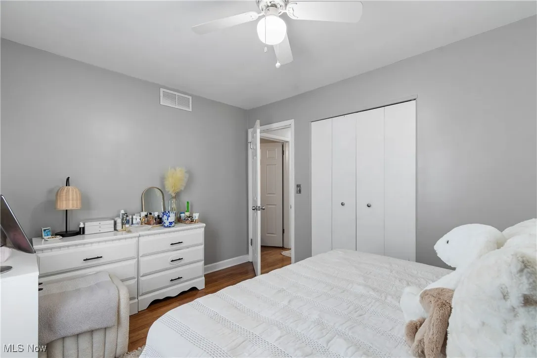 Bedroom featuring dark wood finished floors, a closet, and ceiling fan