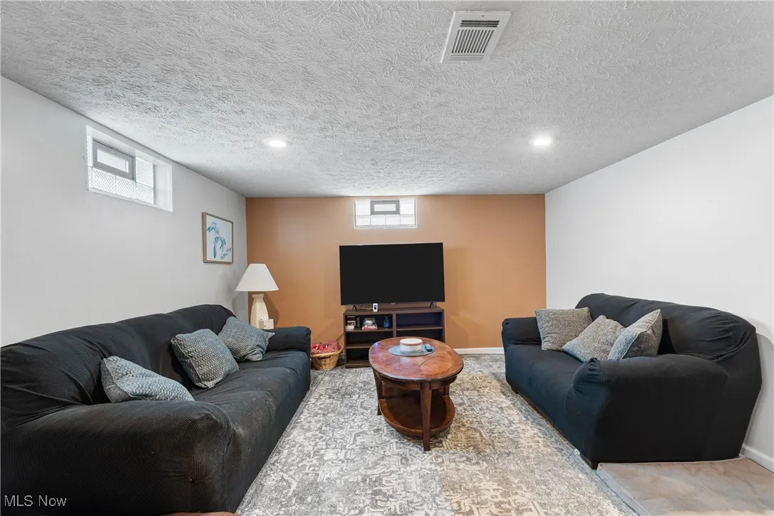 Living room featuring plenty of natural light, a textured ceiling, recessed lighting, and carpet floors