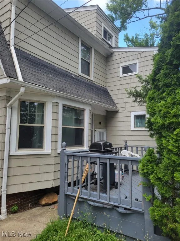 Back of house featuring a deck and a shingled roof