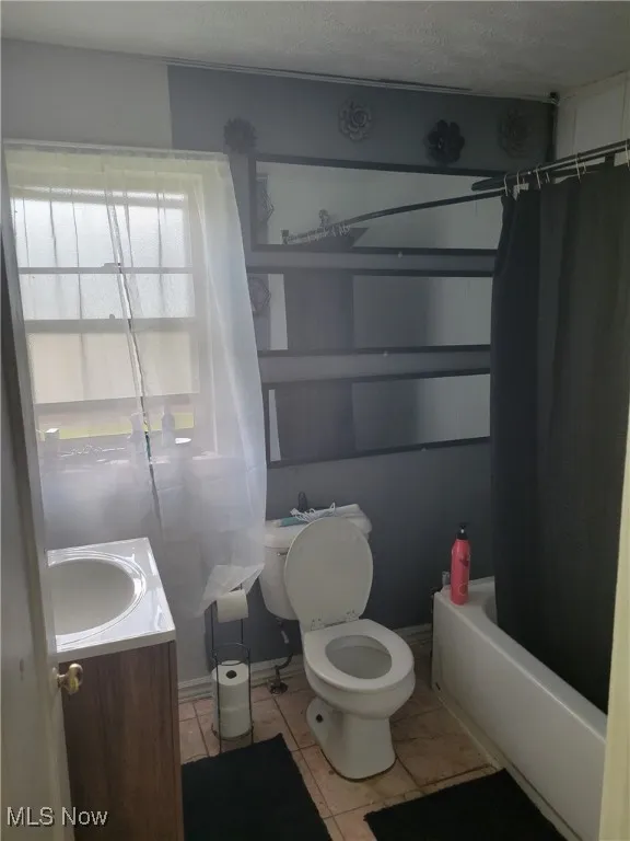 Full bathroom featuring vanity, shower / bath combo, and tile patterned floors