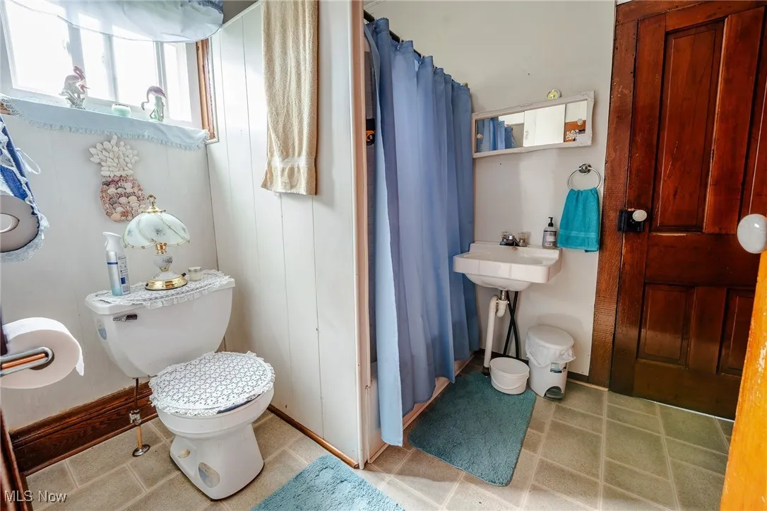 Full bathroom with a shower with curtain and toilet