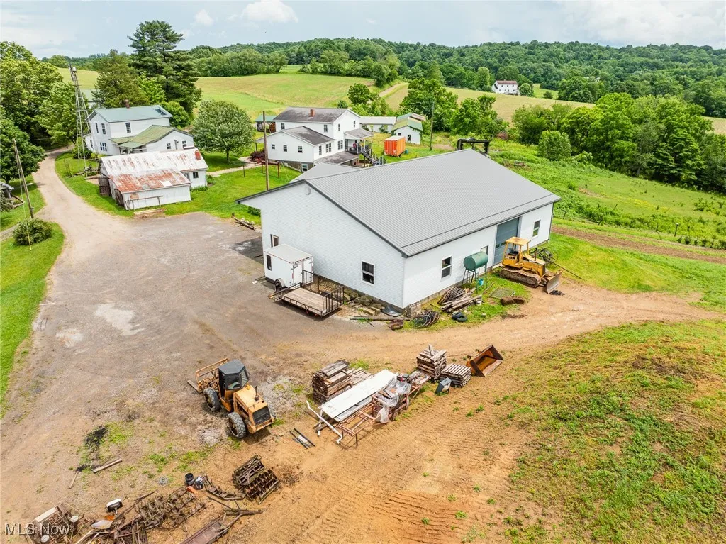 Aerial view of property and surrounding area with a tree filled landscape