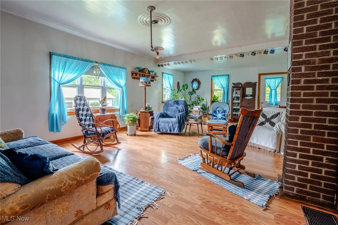 Living area with wood finished floors and crown molding