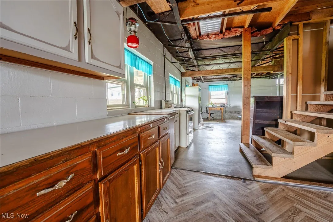 Kitchen with light countertops, white range with gas cooktop, plenty of natural light, and freestanding refrigerator