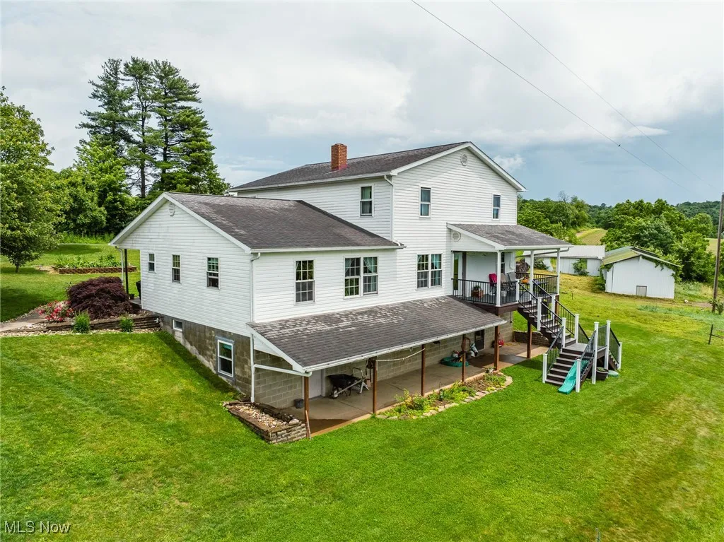 Back of property featuring roof with shingles, a chimney, a yard, a patio area, and stairway