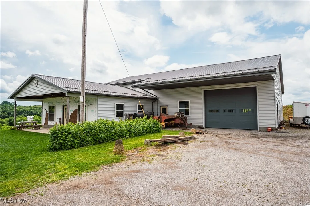 Single story home with driveway, a metal roof, a garage, and a front yard