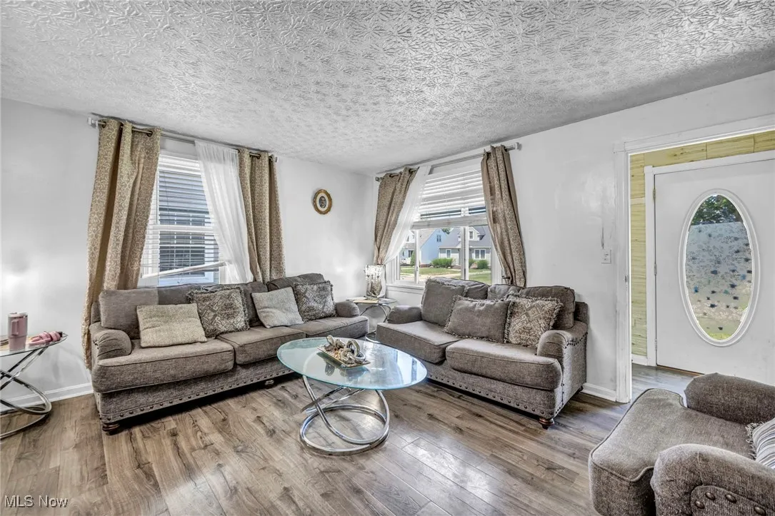 Living area featuring wood finished floors and a textured ceiling