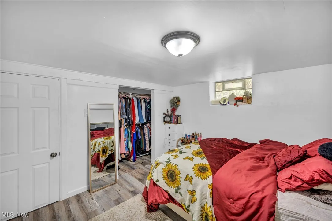 Bedroom with wood finished floors and a closet