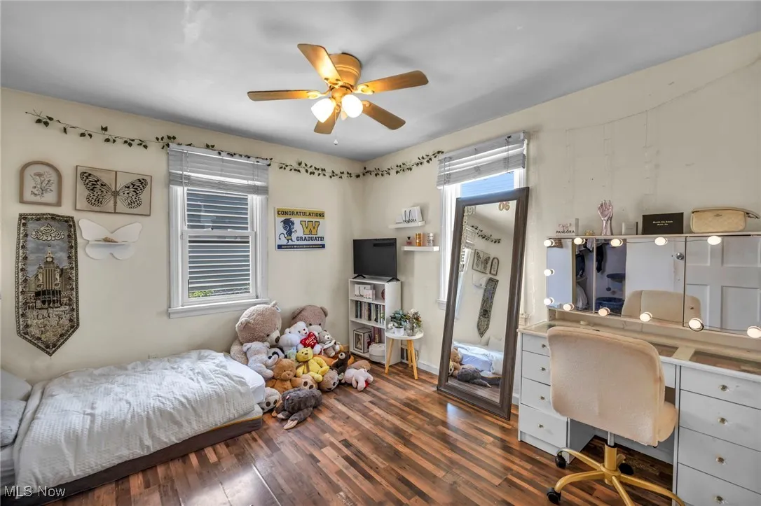 Bedroom featuring a desk, wood finished floors, and a ceiling fan