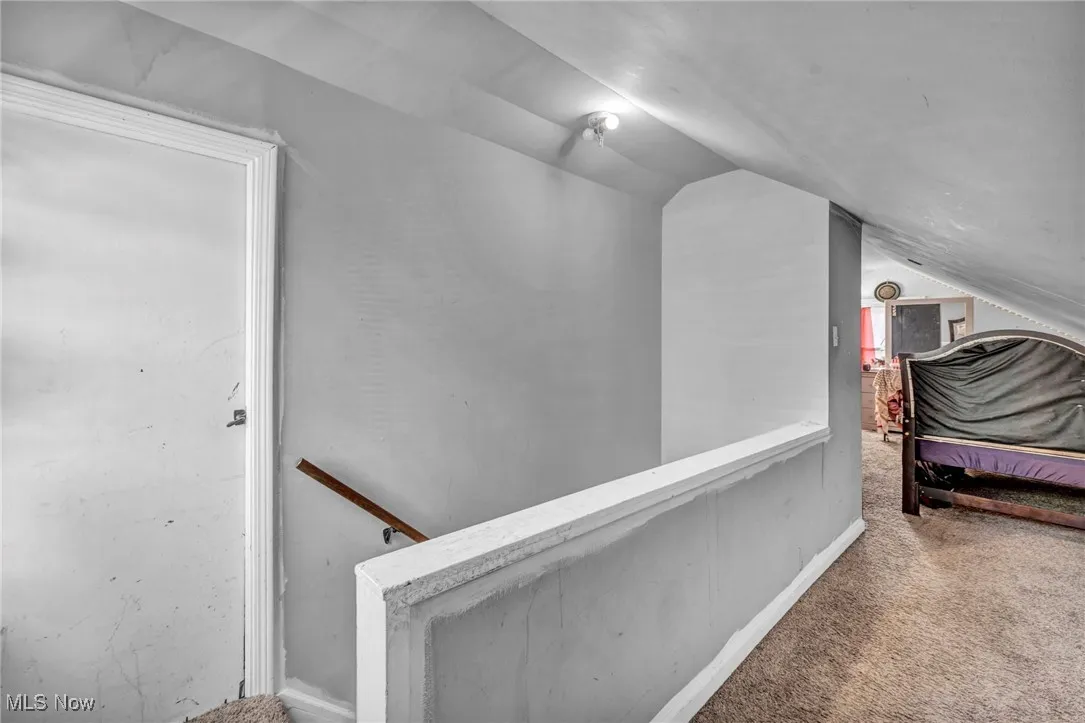 Stairway with lofted ceiling and carpet