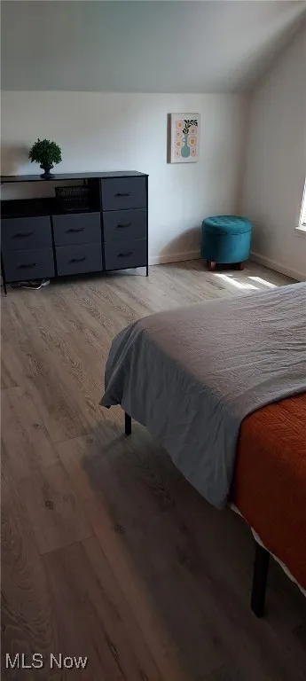 Bedroom with light wood finished floors and baseboards