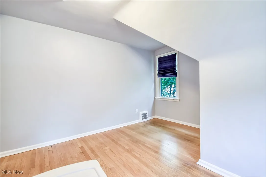 Additional living space with baseboards and light wood-style flooring