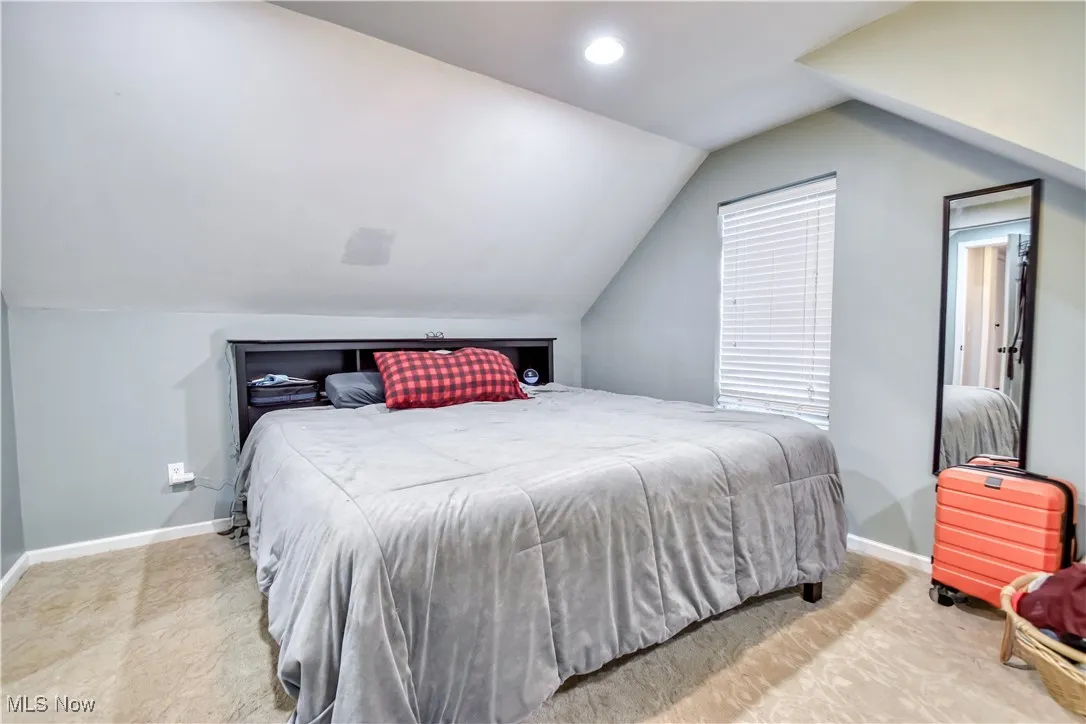 Bedroom with lofted ceiling and recessed lighting
