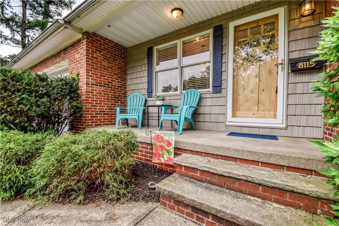 Doorway to property with covered porch and brick siding